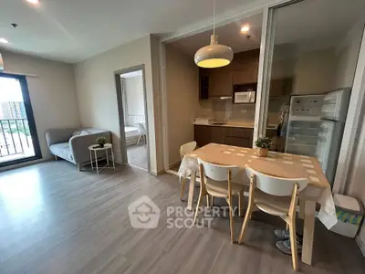 Modern open-plan living room and kitchen with dining area in a stylish apartment.