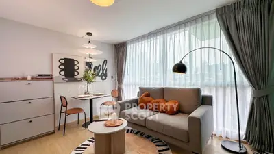 Modern living room with cozy sofa, stylish decor, and large window for natural light.