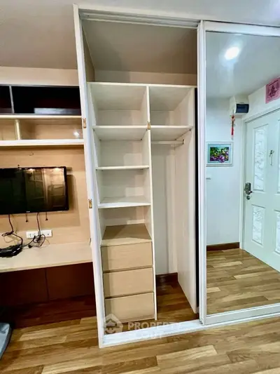 Modern apartment interior with built-in wardrobe and wooden flooring, showcasing efficient storage solutions.