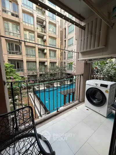 Charming balcony with pool view and modern washing machine in urban apartment setting.