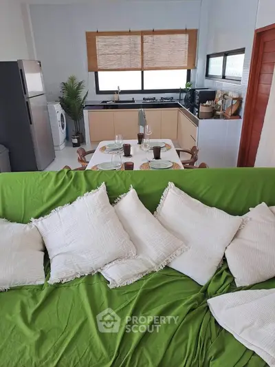 Charming open-layout kitchen with dining area and cozy living space, featuring modern appliances and stylish decor.