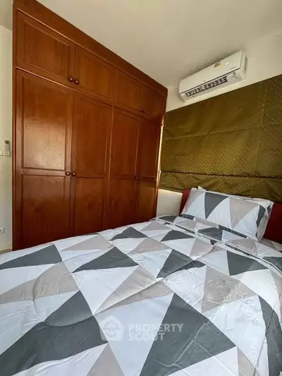 Cozy bedroom with wooden wardrobe and modern air conditioning unit.