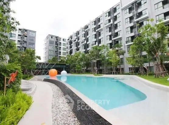 Modern apartment complex with a stylish outdoor pool and lush greenery.