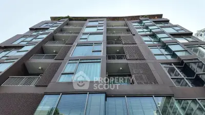 Modern apartment building exterior with large windows and balconies, showcasing contemporary urban living.