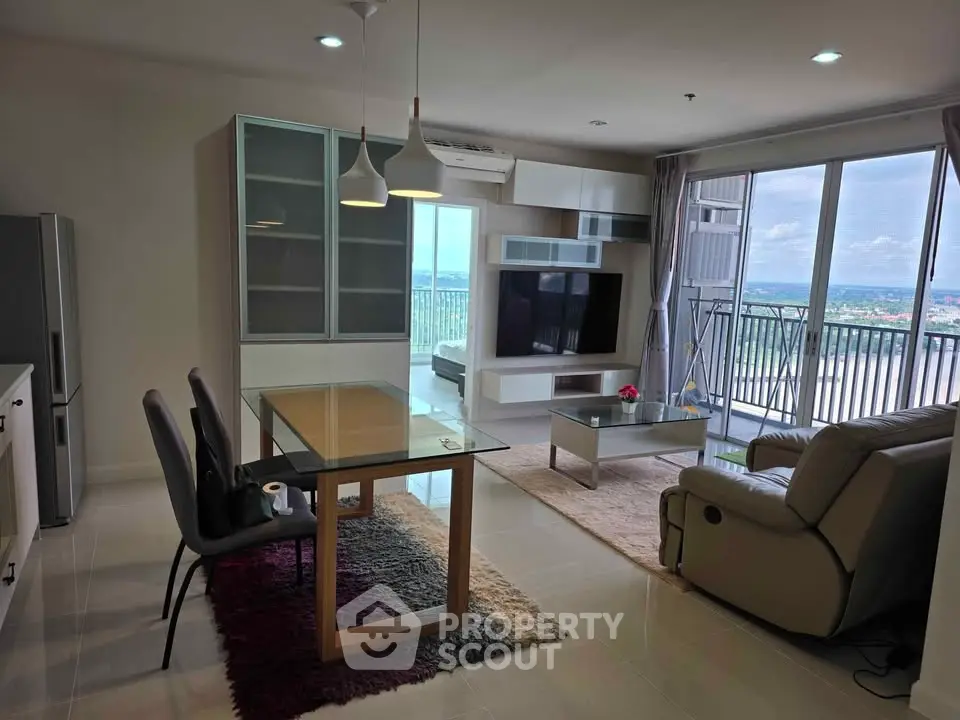 Spacious living room with modern furniture and large balcony offering stunning views.