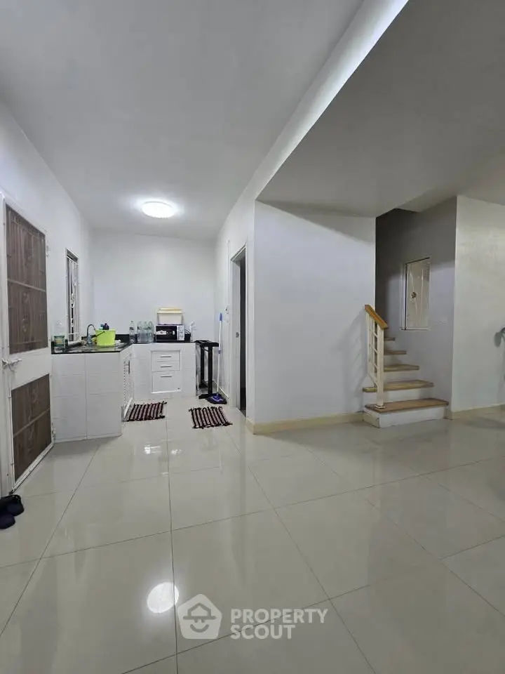 Spacious modern interior with sleek kitchen and staircase, perfect for contemporary living.