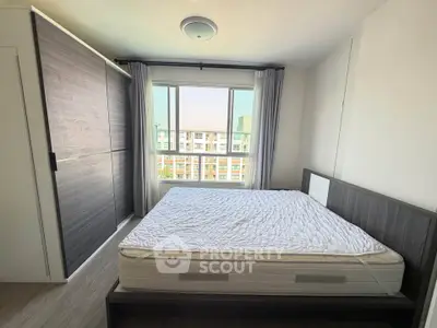 Modern bedroom with large window and stylish wardrobe in a high-rise apartment.