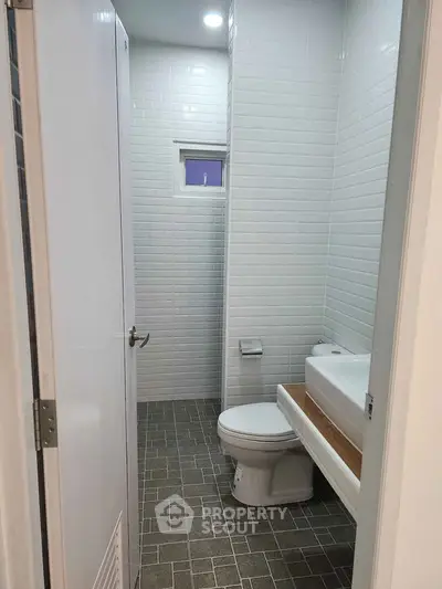 Compact bathroom with modern white tiles and sleek fixtures
