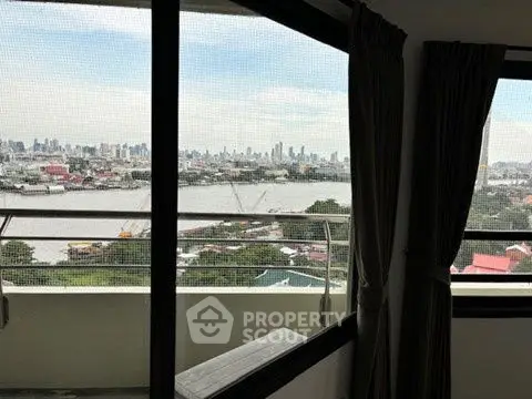 Stunning cityscape view from high-rise apartment balcony with expansive windows.