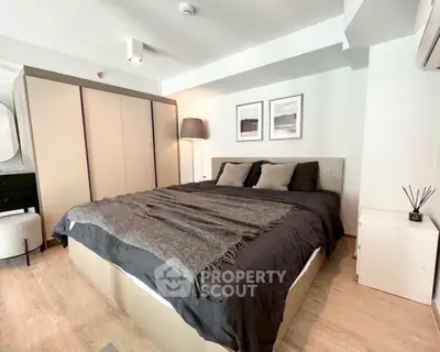 Modern bedroom with stylish decor and cozy ambiance, featuring a large bed and elegant furnishings.
