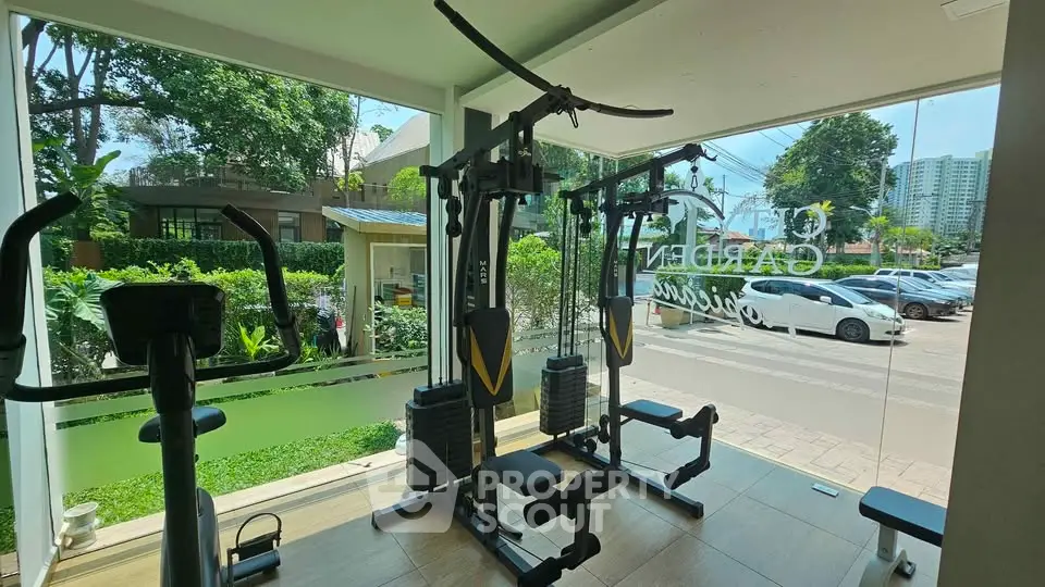 Modern gym with state-of-the-art equipment and large windows overlooking lush greenery.