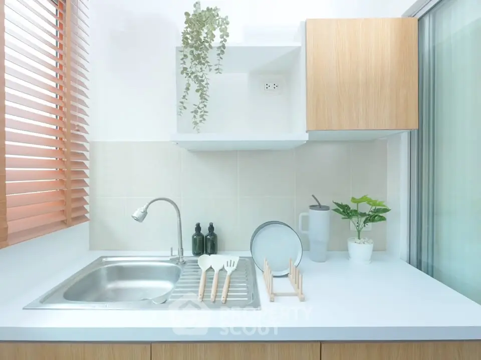Modern kitchen with sleek design, featuring a stainless steel sink and minimalist decor.