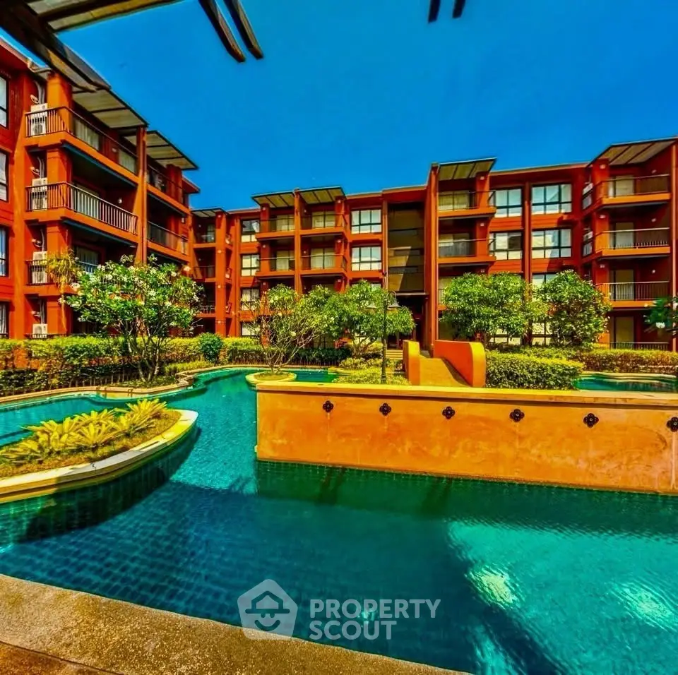 Luxurious apartment complex with stunning pool and lush greenery, perfect for resort-style living.