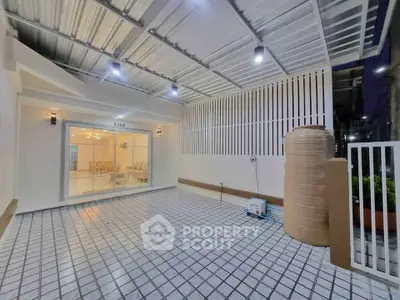 Modern covered patio with tiled flooring and ambient lighting, perfect for outdoor gatherings.