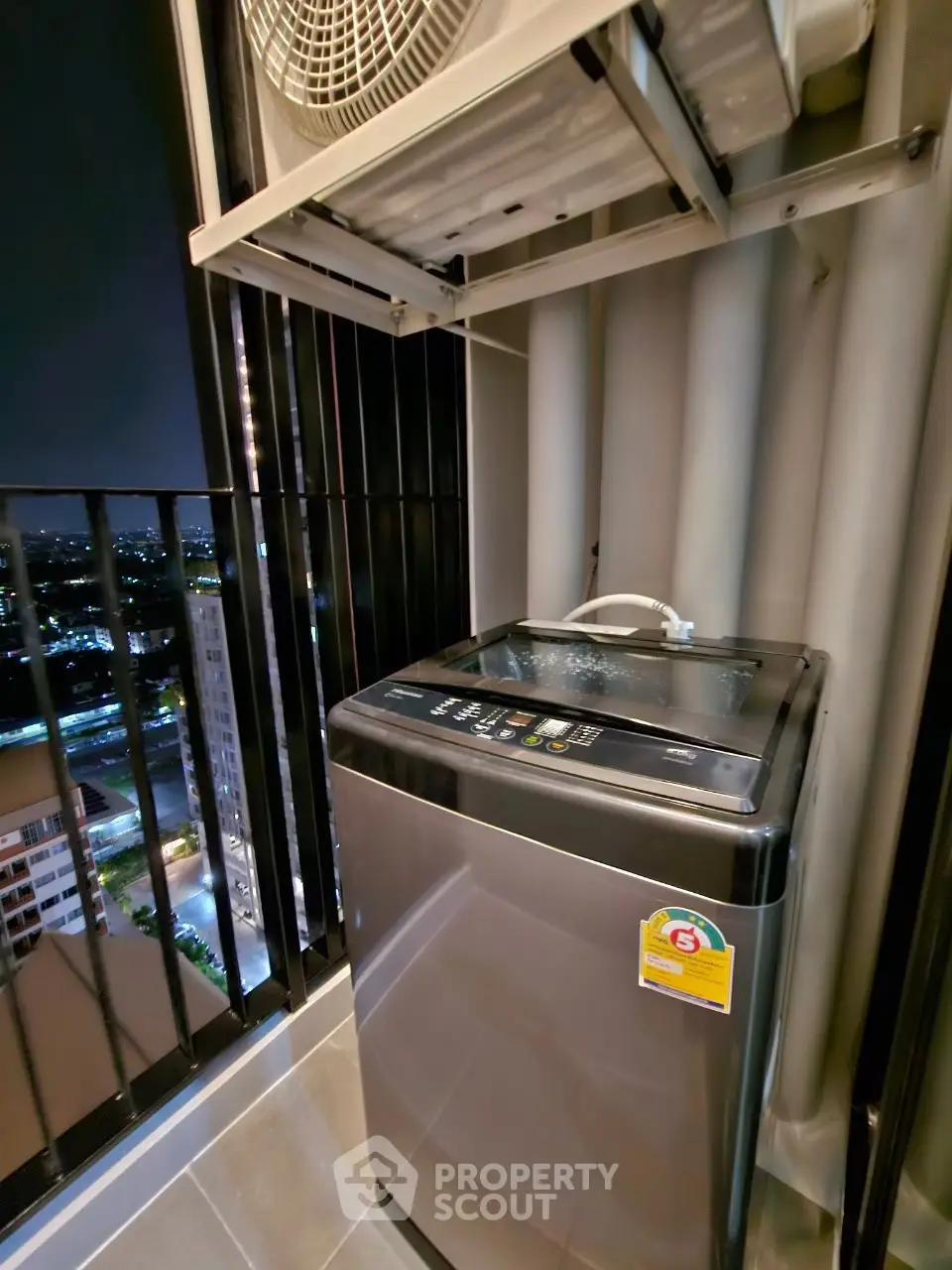 Modern balcony with washing machine and city view at night