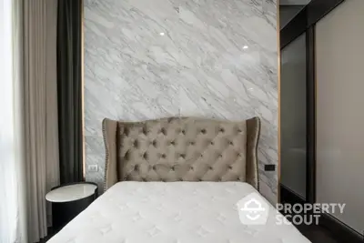 Luxurious bedroom with elegant tufted headboard and marble accent wall