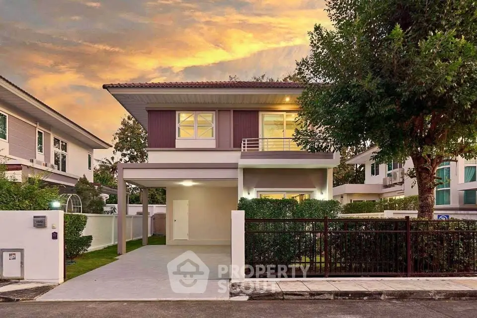 Charming two-story house with modern design and lush greenery at sunset.