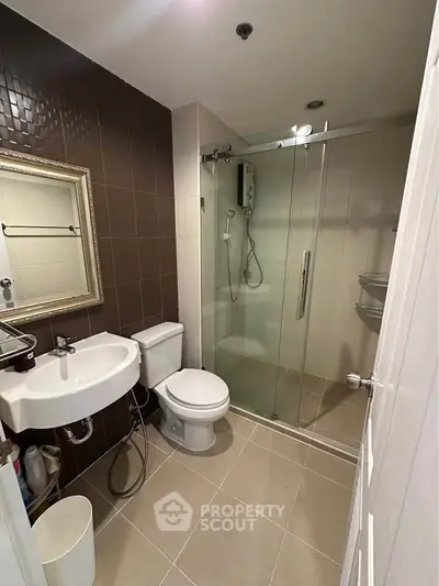 Modern bathroom with glass shower and elegant fixtures in a stylish apartment.