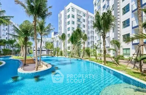 Luxurious apartment complex with stunning pool and lush palm trees.