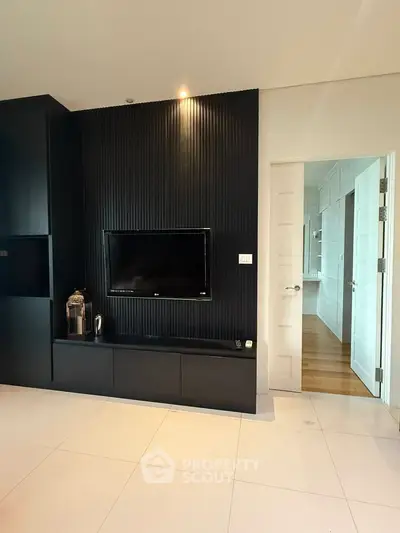 Modern living room with sleek black entertainment wall and flat-screen TV.