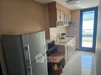 Modern kitchen with sleek appliances and balcony access in a stylish apartment.