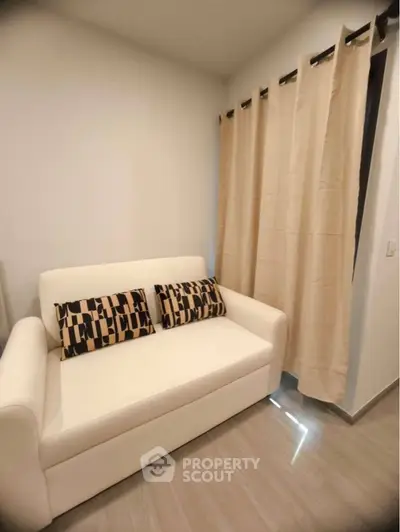 Cozy living room with modern white sofa and stylish patterned cushions