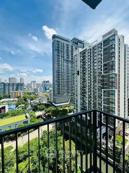 Stunning cityscape view from high-rise balcony with lush greenery and modern buildings.