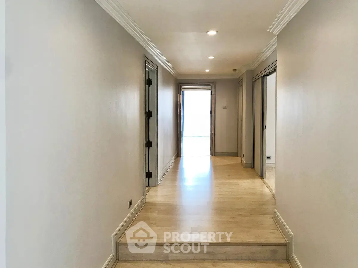 Spacious hallway with elegant wooden flooring and bright natural light