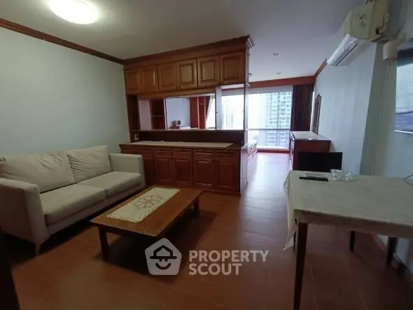 Spacious living room with cozy sofa and wooden accents in modern apartment.