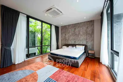 Spacious bedroom with large windows and modern decor in luxury home