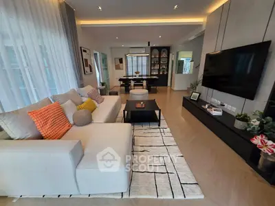 Modern living room with stylish decor and open layout, featuring a cozy sofa and large TV.
