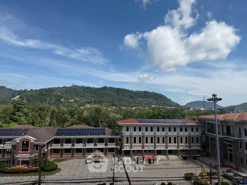 Stunning view of a modern building complex with solar panels and scenic mountain backdrop.