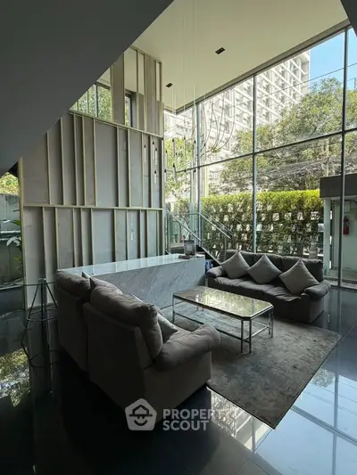 Luxurious modern living room with floor-to-ceiling windows and elegant furnishings in a high-rise building.