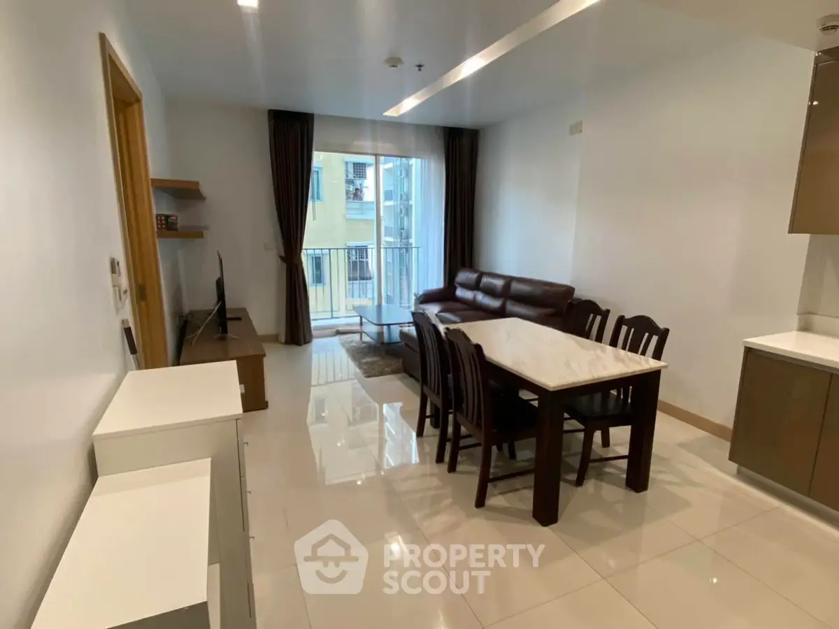 Modern living room with dining area and balcony access in a stylish apartment.