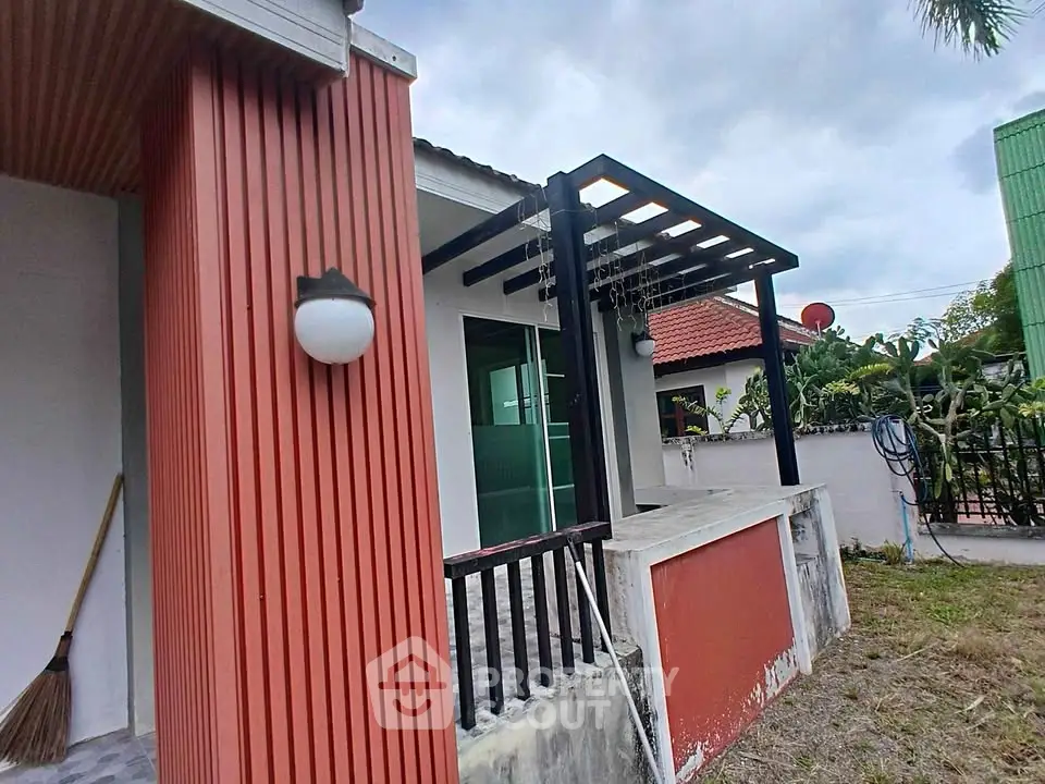 Charming single-story home with modern pergola and vibrant exterior, perfect for outdoor relaxation.