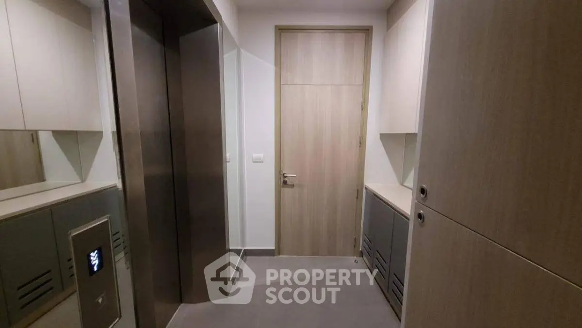 Modern apartment elevator lobby with sleek design and wooden accents.