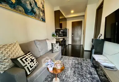 Modern living room with stylish decor and open kitchen layout in a cozy apartment.