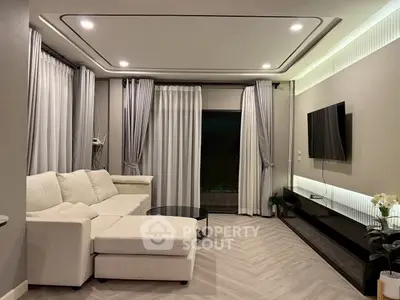 Modern living room with elegant decor and sleek furniture, featuring a cozy sectional sofa and wall-mounted TV.