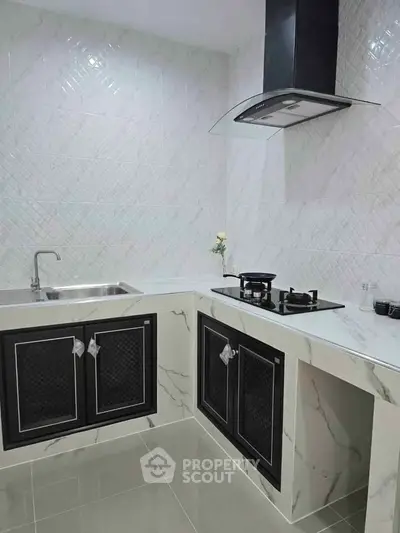 Modern kitchen with sleek marble countertops and gas stove