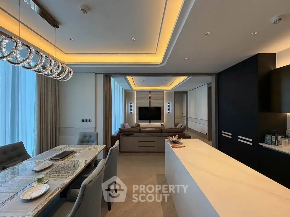 Luxurious open-plan living room with modern kitchen and elegant dining area, featuring ambient lighting and sleek design.