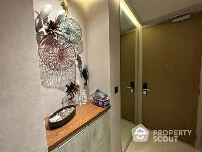 Stylish modern apartment entrance with decorative wall art and sleek wooden door