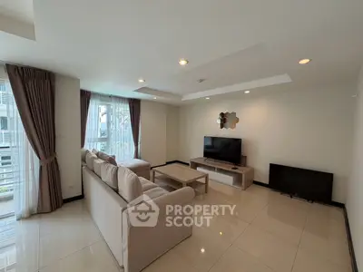 Spacious modern living room with elegant decor and large windows offering natural light.