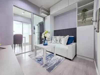 Modern living room with stylish decor and open layout leading to a bright kitchen area.