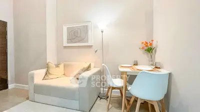 Cozy living room with modern decor and dining area, perfect for urban living.