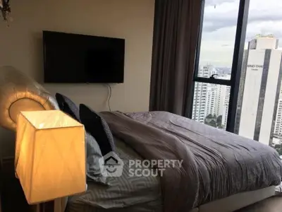 Modern bedroom with city view and stylish decor in high-rise apartment.