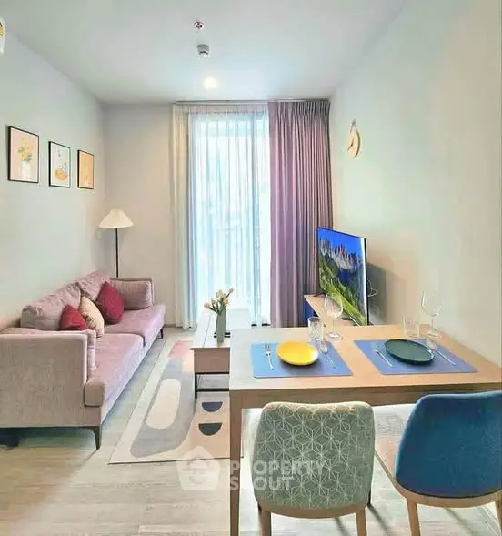 Modern living room with stylish decor and dining area, featuring a cozy sofa and flat-screen TV.