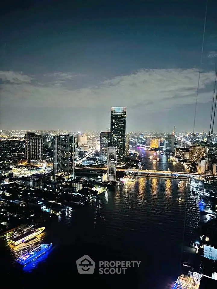 Stunning cityscape view of a vibrant skyline at night with illuminated buildings and river.