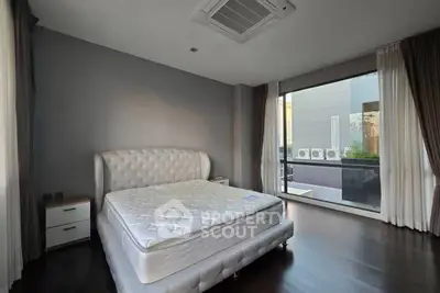 Spacious bedroom with elegant design and large windows offering natural light and a serene view.