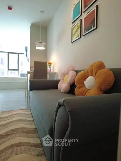 Charming living room with cozy sofa and flower cushions, perfect for relaxation and entertaining guests.