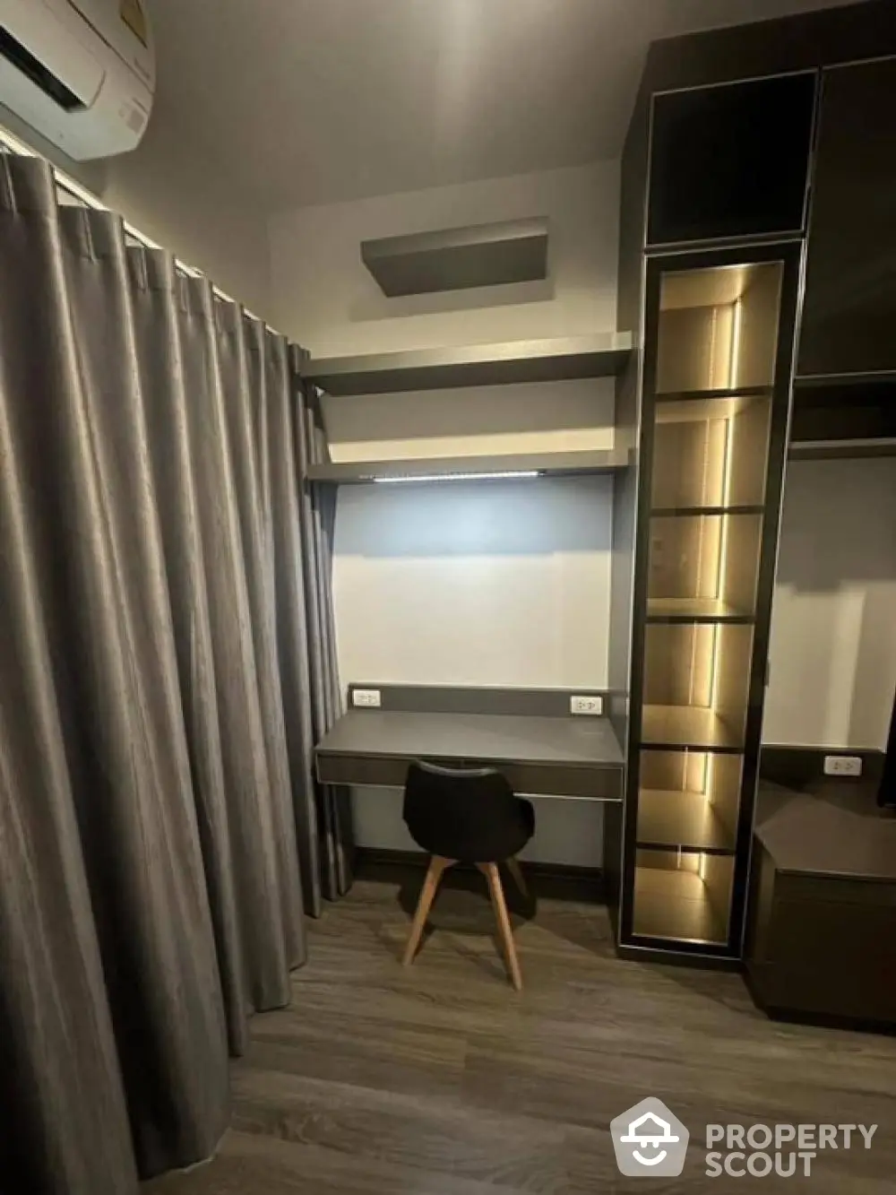 Modern study room with sleek desk and chair, elegant shelving, and ambient lighting.